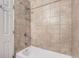 Shower over tub featuring neutral tile and chrome hardware at 2060 W Iliff Ave, Englewood, CO 80110