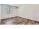 Simple bedroom features wood floors, white walls, AC unit, and natural light from the window at 2060 W Iliff Ave, Englewood, CO 80110
