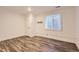 An empty room with hardwood floors, white walls, and a window that offers natural light at 2060 W Iliff Ave, Englewood, CO 80110