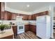 Functional kitchen equipped with white appliances, wooden cabinets, and durable flooring at 2060 W Iliff Ave, Englewood, CO 80110