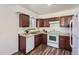 Efficient kitchen design with wood cabinets, white appliances, and plenty of countertop space at 2060 W Iliff Ave, Englewood, CO 80110