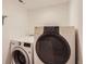 Laundry room with modern white washer and dryer appliances against a white wall at 2060 W Iliff Ave, Englewood, CO 80110