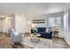 Inviting living room with wood floors, blue sofa, decorative rug, and an abundance of natural light at 2060 W Iliff Ave, Englewood, CO 80110