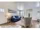 Cozy living room featuring a plush blue sofa, hardwood floors, and an abundance of natural light at 2060 W Iliff Ave, Englewood, CO 80110