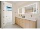 Bright bathroom featuring double sinks, modern cabinets, and a large, illuminated mirror at 1601 S Columbine St, Denver, CO 80210