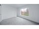 Bright bedroom features a large window, neutral carpet, and minimalist decor at 16086 E Ithaca Pl # D, Aurora, CO 80013