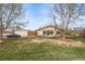 Exterior front view of the home with a car, large lawn, and mature trees at 16086 E Ithaca Pl # D, Aurora, CO 80013
