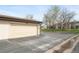 Attached single-car garage with a light-colored door and ample parking space in front at 16086 E Ithaca Pl # D, Aurora, CO 80013