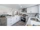 Modern kitchen showcases white cabinets, stainless steel appliances, and an open design flowing into the living area at 16086 E Ithaca Pl # D, Aurora, CO 80013
