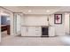 Basement bar area with granite counters, white cabinets, and a stainless steel beverage center at 4505 S Yosemite St # 102, Denver, CO 80237