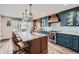 Modern kitchen with custom cabinets, a large island, pendant lighting, and stainless-steel appliances at 4505 S Yosemite St # 102, Denver, CO 80237