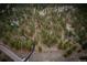 Aerial view of a home nestled among dense trees with a winding driveway leading to the property at 7572 Kelty Trl, Franktown, CO 80116