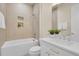 Elegant bathroom featuring a soaking tub with tiled wall surround, shower head, and vanity sink with decorative plant at 7572 Kelty Trl, Franktown, CO 80116