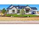 Charming exterior elevation with stone accents, manicured lawn, and a welcoming entrance to this inviting home at 7572 Kelty Trl, Franktown, CO 80116