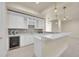 Modern kitchen with white cabinetry, tiled backsplash, wine rack, quartz countertops, and stainless steel wine cooler at 7572 Kelty Trl, Franktown, CO 80116