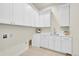 Well-organized laundry room featuring white cabinets and counter space at 7572 Kelty Trl, Franktown, CO 80116