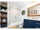Beautiful bathroom featuring navy cabinets, a glass-enclosed shower, and stylish fixtures, for a modern yet functional space at 6787 Serena Ave, Castle Pines, CO 80108