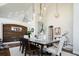 Stylish dining room with wood accent wall, modern chandelier, and a large table perfect for gatherings at 6787 Serena Ave, Castle Pines, CO 80108