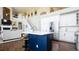 Open concept kitchen with a navy-blue island, white countertops, stainless appliances, and easy access to living space at 6787 Serena Ave, Castle Pines, CO 80108