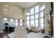 Bright living room with soaring windows, neutral decor, and open floor plan to the modern kitchen at 6787 Serena Ave, Castle Pines, CO 80108