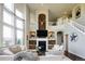 Inviting living room featuring a fireplace, comfortable seating, and staircase access to the upper level at 6787 Serena Ave, Castle Pines, CO 80108