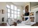Spacious living room with soaring ceilings, large windows, and cozy fireplace, perfect for gatherings and relaxation at 6787 Serena Ave, Castle Pines, CO 80108