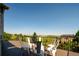 Wooden deck with black railing and white metal chairs offers stunning mountain and meadow views at 6787 Serena Ave, Castle Pines, CO 80108