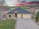 Stucco home featuring a two-car garage, stone accents, and well-maintained lawn at 9754 W Ontario Pl, Littleton, CO 80128