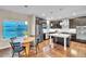 An open concept kitchen features stainless steel appliances, dark cabinetry, an island and a table at 9754 W Ontario Pl, Littleton, CO 80128