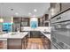 An open concept kitchen features stainless steel appliances, dark cabinetry, and a white countertop island at 9754 W Ontario Pl, Littleton, CO 80128