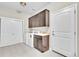 Bright laundry room featuring a washer, dryer, sink, cabinets, tile floor, and white doors at 9754 W Ontario Pl, Littleton, CO 80128