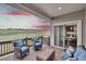 Covered patio with brown wood deck, wicker furniture, blue cushions, and view of green fields at sunset at 9754 W Ontario Pl, Littleton, CO 80128