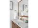 Modern bathroom with a wood-framed mirror, marble countertop, and gold fixtures at 3065 S Eudora St, Denver, CO 80222
