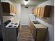 Cozy kitchen featuring a white range, stainless steel sink, refrigerator, and wood cabinets at 10211 Ura Ln # 9-308, Thornton, CO 80260