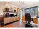 Cozy office space with built in cabinets, wood floors, large window, and french doors to the home's exterior at 9365 W 80Th Pl # C, Arvada, CO 80005
