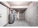 Unfinished basement with a water heater, exposed pipes and access to upper level at 19240 E Carolina Dr # 104, Aurora, CO 80017