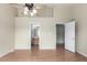 Bedroom with wood floors, ceiling fan, and open doors to bathroom and closet at 19240 E Carolina Dr # 104, Aurora, CO 80017