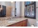 Bathroom featuring granite countertop, mosaic backsplash, and window with scenic outdoor view at 160 N Fuller Placer Rd, Breckenridge, CO 80424