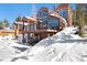 Beautiful exterior view of home with multiple windows, deck, and snow around the house at 160 N Fuller Placer Rd, Breckenridge, CO 80424