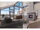 Inviting living room with soaring windows, stone fireplace, and comfortable seating at 160 N Fuller Placer Rd, Breckenridge, CO 80424