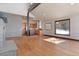 Open living room with wood floors, stone accent wall, and ample natural light from large window at 160 N Fuller Placer Rd, Breckenridge, CO 80424