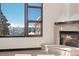 Living room with stone fireplace and expansive windows showcasing mountain views at 160 N Fuller Placer Rd, Breckenridge, CO 80424