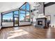 Bright living room with stone fireplace, wood floors, and expansive windows showcasing mountain views at 160 N Fuller Placer Rd, Breckenridge, CO 80424