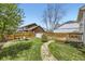 Expansive backyard featuring a stone path that leads to a wood deck and a cozy seating area at 3803 Dyanna Dr, Thornton, CO 80241