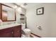 Cozy bathroom featuring a wood vanity and a standard toilet with decor elements at 3803 Dyanna Dr, Thornton, CO 80241