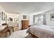 Bright bedroom with en suite bathroom featuring a wooden bed, plush carpet, and dresser at 3803 Dyanna Dr, Thornton, CO 80241