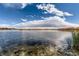 Calm lake with reflections of the sky and distant trees, promoting a serene and natural setting at 3803 Dyanna Dr, Thornton, CO 80241