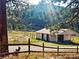 Scenic barn surrounded by a white fence, offering a serene and pastoral setting for equestrian pursuits at 3841 Myers Gulch Rd, Kittredge, CO 80457