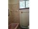 Bathroom featuring a tiled shower, handrails, and a window, offering functionality and accessibility at 3841 Myers Gulch Rd, Kittredge, CO 80457