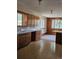 Kitchen with tiled floors, wood cabinetry, and an adjacent dining area with natural light streaming through the windows at 3841 Myers Gulch Rd, Kittredge, CO 80457